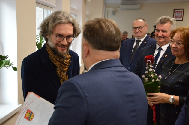 Nauczyciel w PSM I St. w Lipnie Kamil Węgorek  odbiera nagrodę z rąk Starosty Lipnowskiego Krzysztofa Baranowskiego podczas sesji Rady Powiatu w Lipnie 
